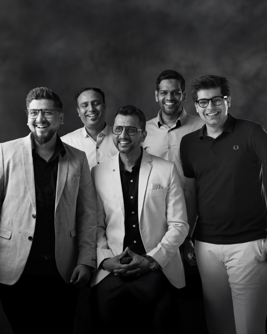 Five team members in a black and white group portrait